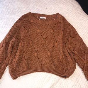 A burnt orange woven sweater